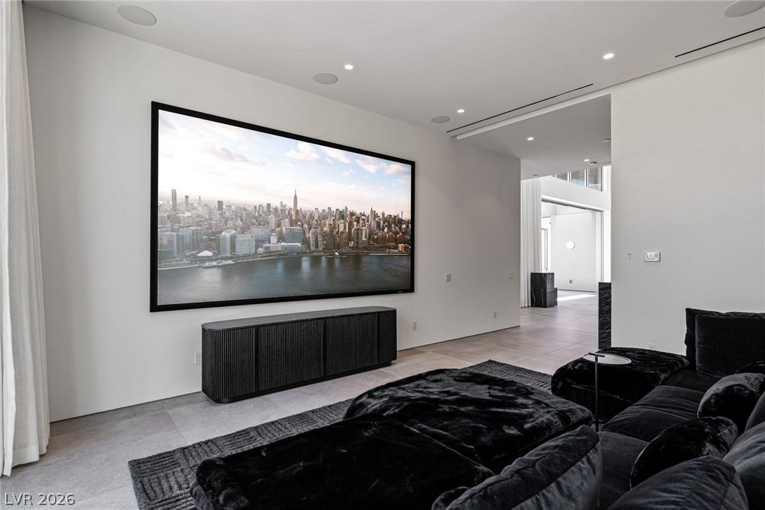 A spacious living room features recessed lighting and tile flooring, offering a perfect setting for entertainment.
