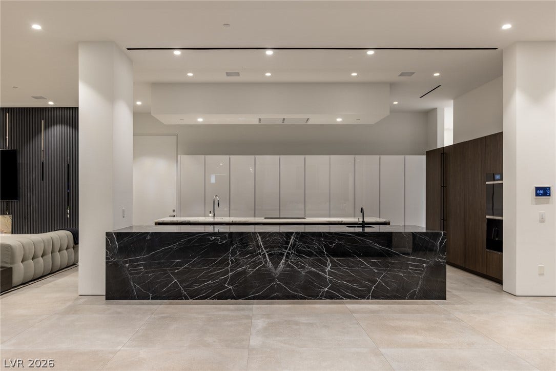 A gourmet kitchen boasts a striking marble island, complementing sleek cabinetry and integrated appliances.
