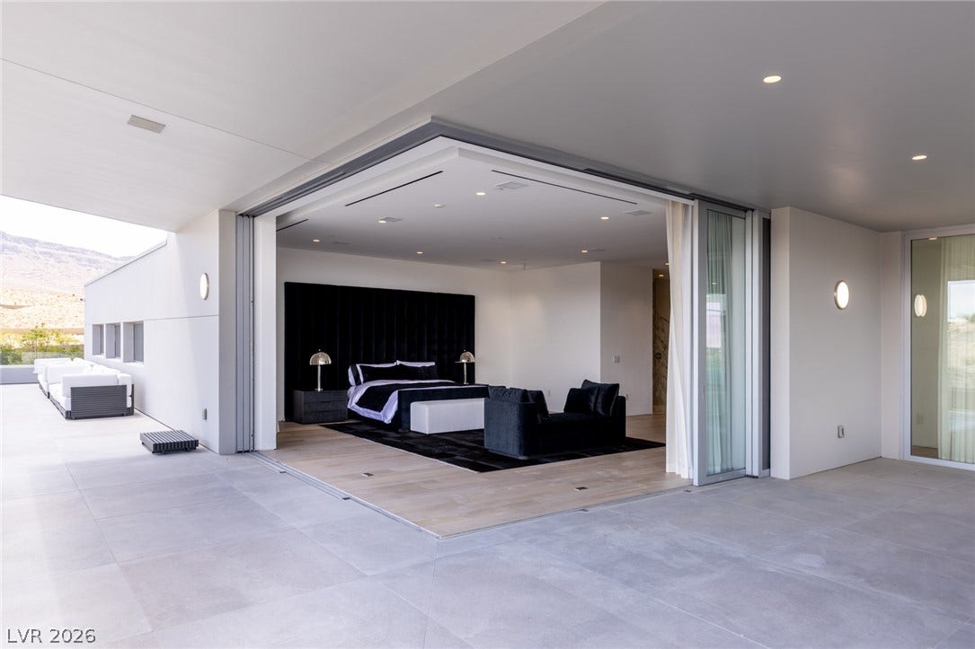 An outdoor patio seamlessly transitions to a bedroom with large sliding glass doors.