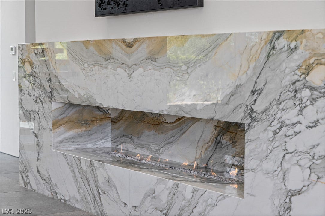 A striking fireplace crafted from veined marble offers warmth and a contemporary focal point.