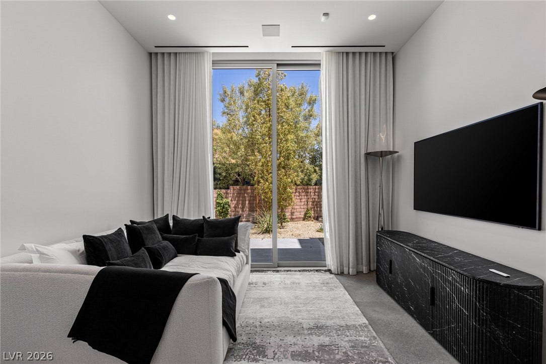 Floor-to-ceiling glass sliding doors illuminate this inviting living area, seamlessly connecting indoors with the tranquil outdoor space.