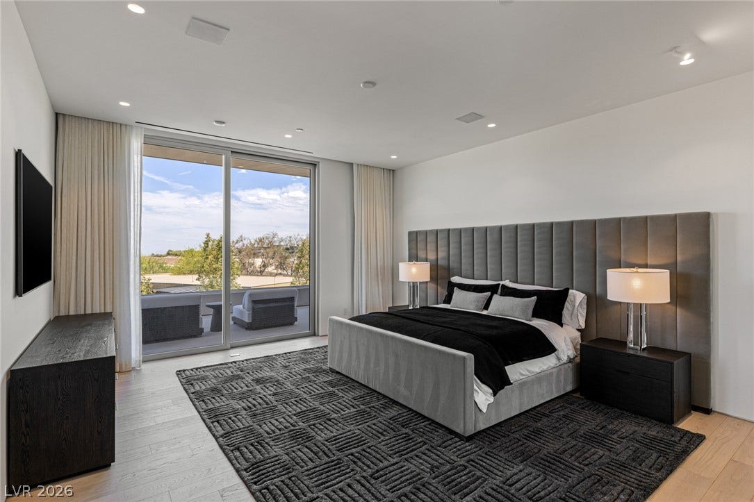 Generous sliding glass doors open to an outdoor terrace, extending the living space of this tranquil primary bedroom.