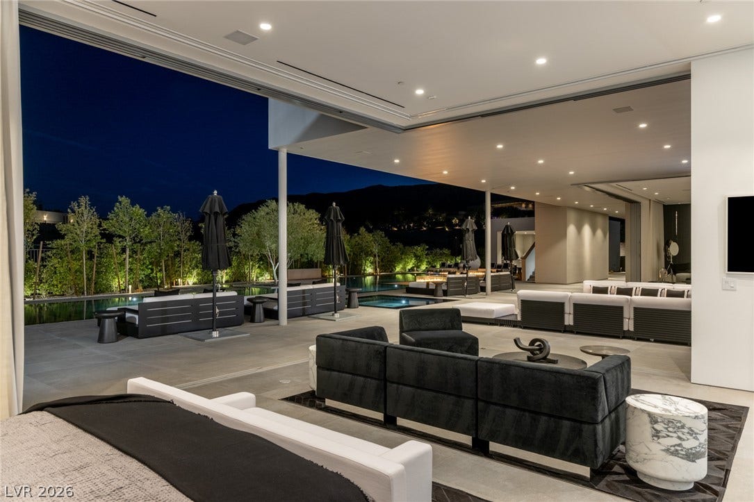 An inviting outdoor living space with pool and seating areas, perfect for evening entertainment.