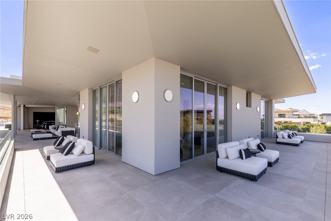 An expansive outdoor patio, ideal for entertaining, offers serene views and a sophisticated lounging experience.