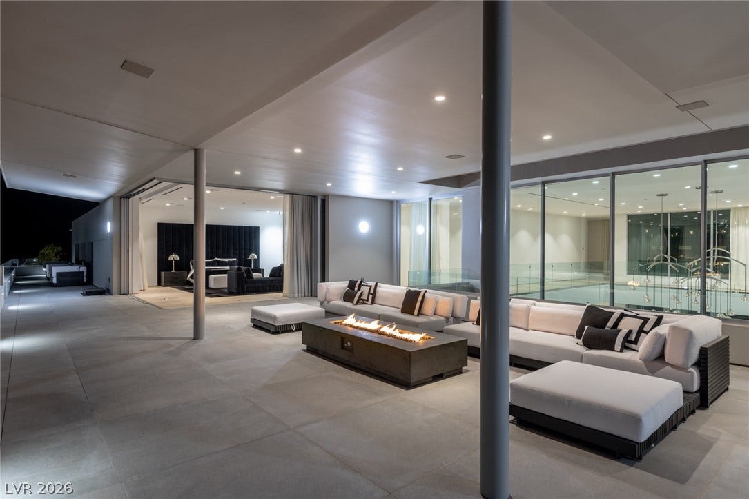 An inviting outdoor lounge area features a fire pit, comfortable seating, and a view of the adjacent indoor pool.