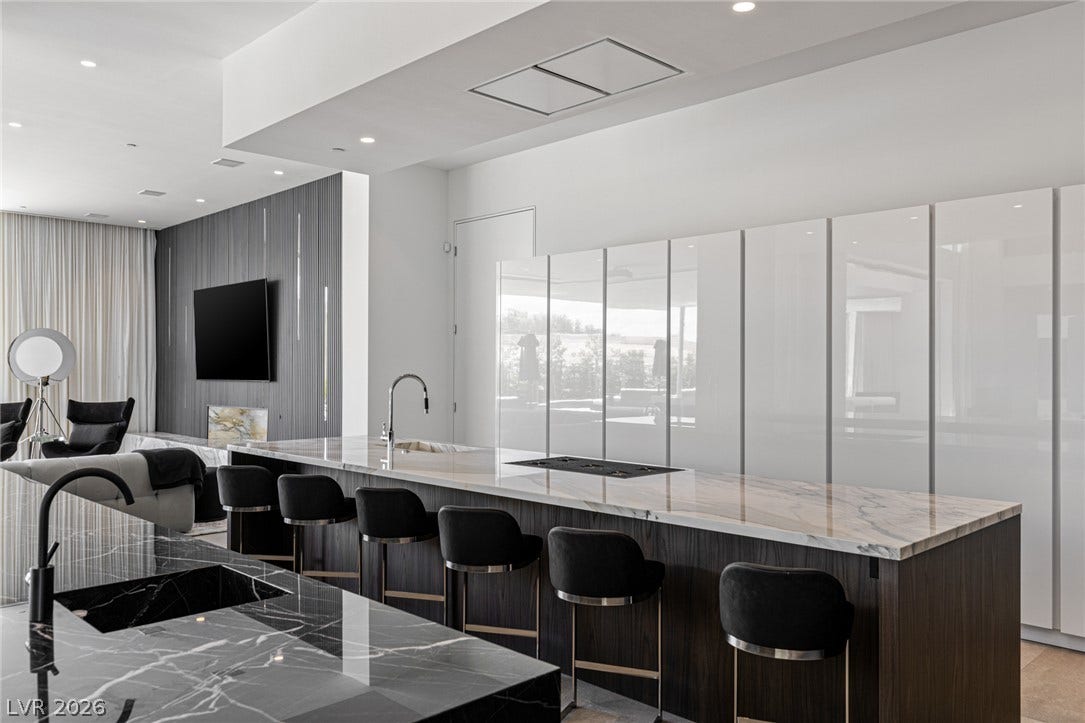 A chic open-concept kitchen features a spacious island with bar seating and integrated cooktop.