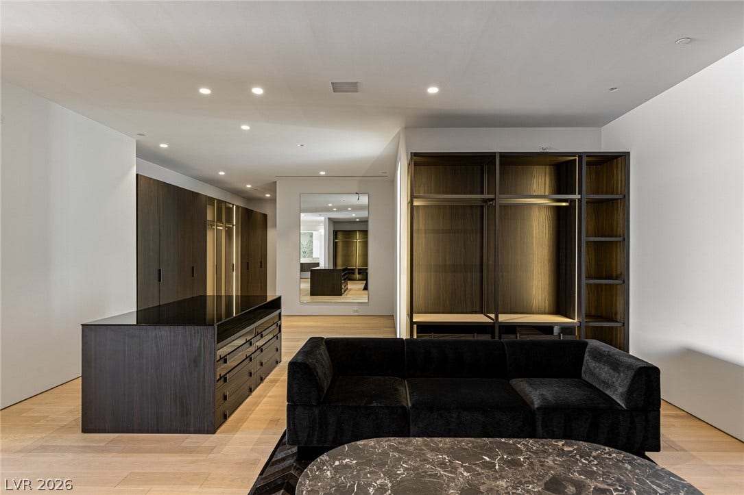 Luxurious walk-in closet with abundant storage and warm, ambient lighting.