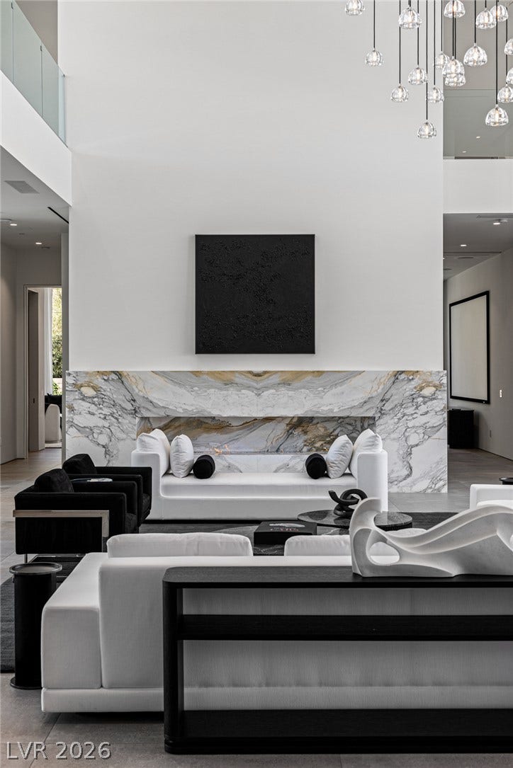 Marble-clad fireplace and towering ceilings enhance this luminous, modern living space.