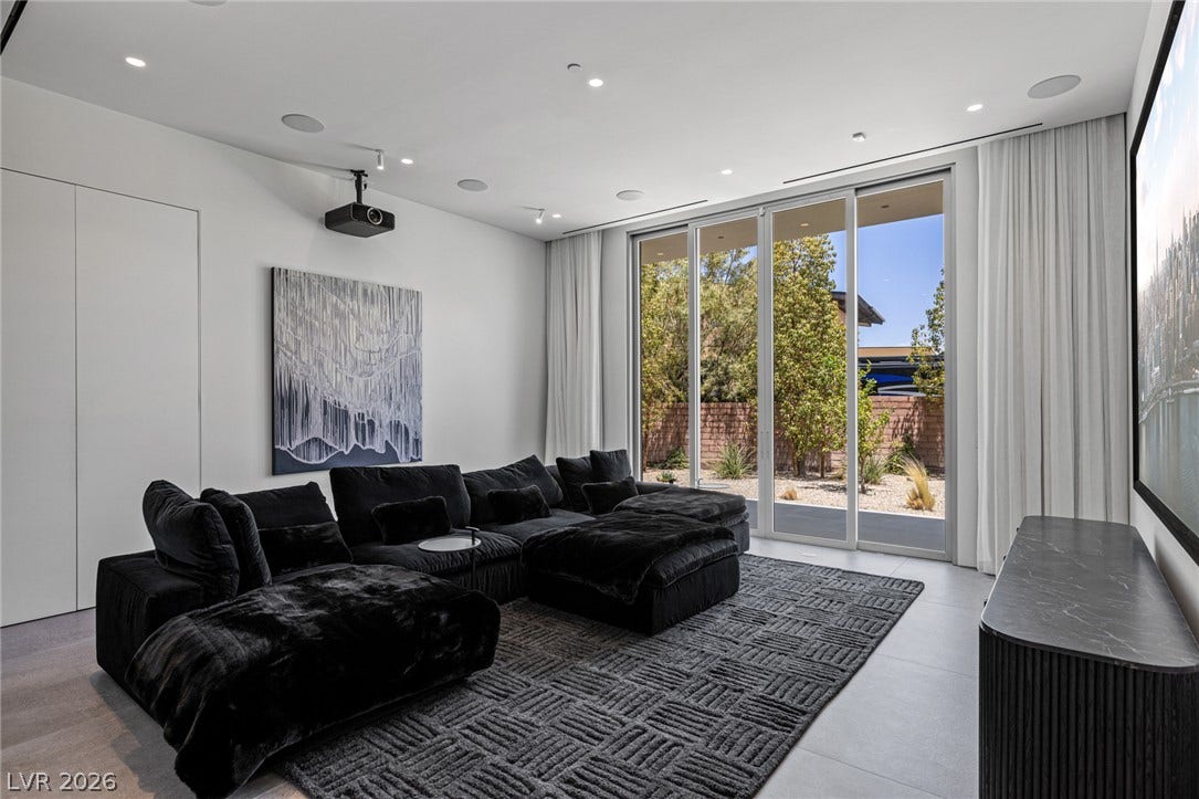An inviting media room for cinematic experiences, complete with direct outdoor access and sophisticated ceiling lighting.