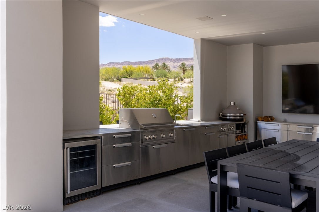 An outdoor kitchen features stainless steel appliances and ample counter space, perfect for al fresco dining.