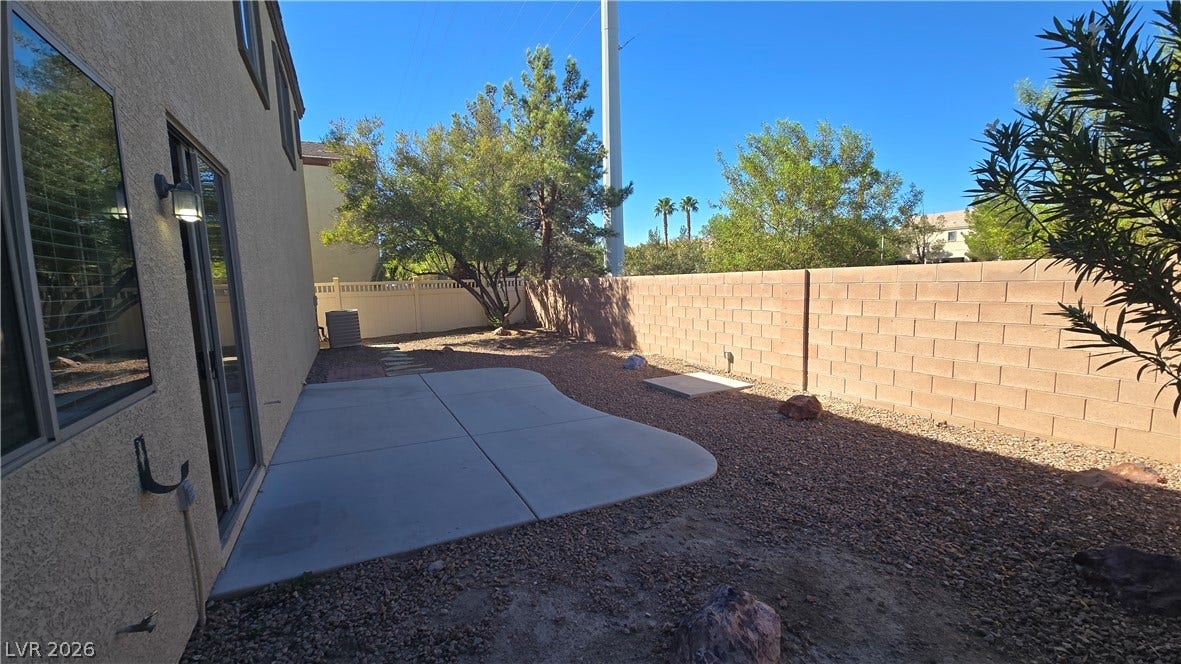 536 Civic Holiday Avenue, North Las Vegas, NV 89031 Enclosed block fencing borders a low-maintenance gravel yard with a poured concrete patio.