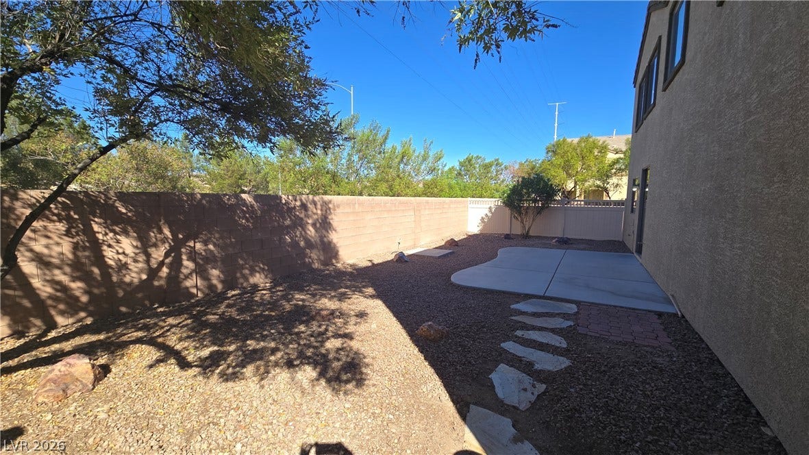 536 Civic Holiday Avenue, North Las Vegas, NV 89031 High privacy walls enclose this low-maintenance desert yard featuring a concrete patio pad.