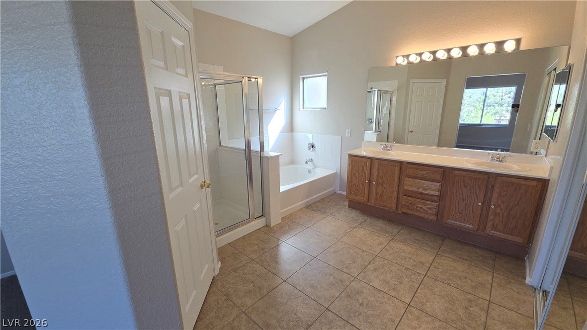 536 Civic Holiday Avenue, North Las Vegas, NV 89031 High vaulted ceilings and tile flooring enhance this master bathroom with a large double vanity.