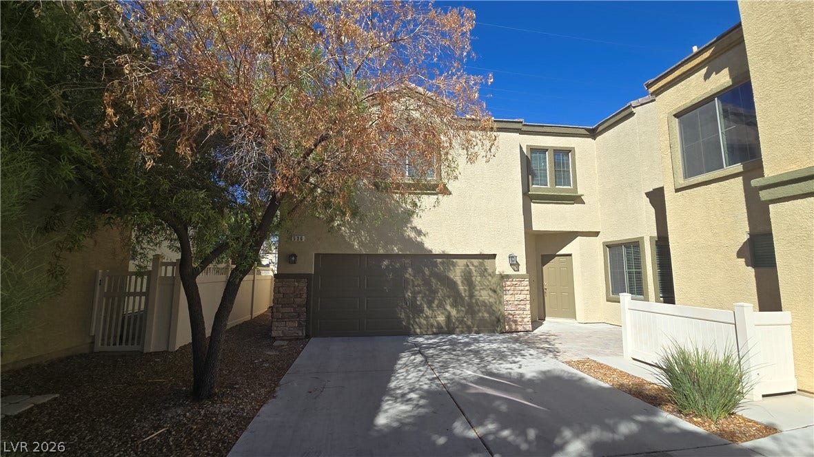 536 Civic Holiday Avenue, North Las Vegas, NV 89031 A spacious driveway leads directly to a private multi-car garage beneath classic stucco architecture.