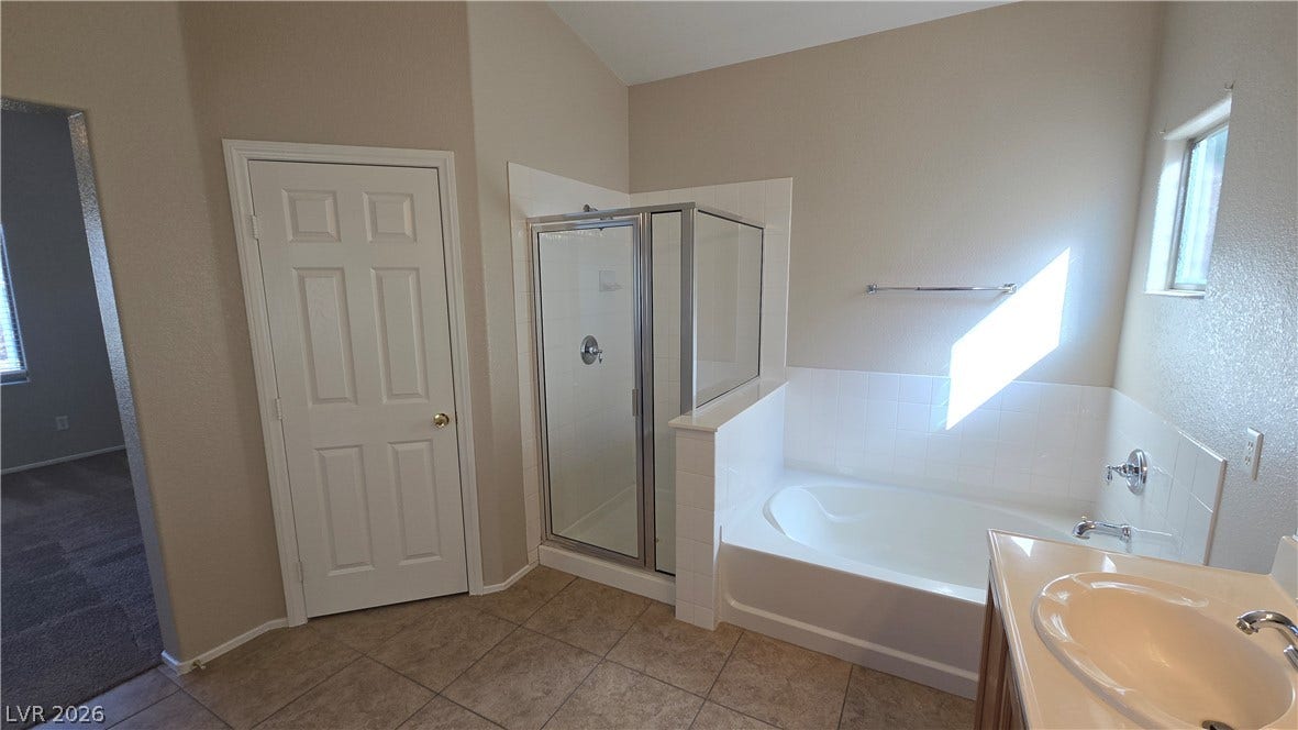 536 Civic Holiday Avenue, North Las Vegas, NV 89031 Vaulted ceilings and tiled floors elevate this private bathroom featuring a separate soaking tub and shower.