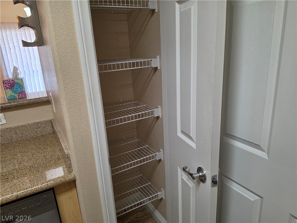 8000 W Badura Avenue, #2111, Las Vegas, NV 89113 A functional pantry closet near the kitchen features built-in wire shelving for organization.