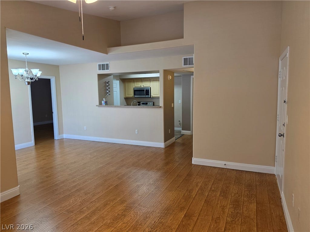 8000 W Badura Avenue, #2111, Las Vegas, NV 89113 Rich wood flooring runs throughout this spacious living area with elevated ceilings.