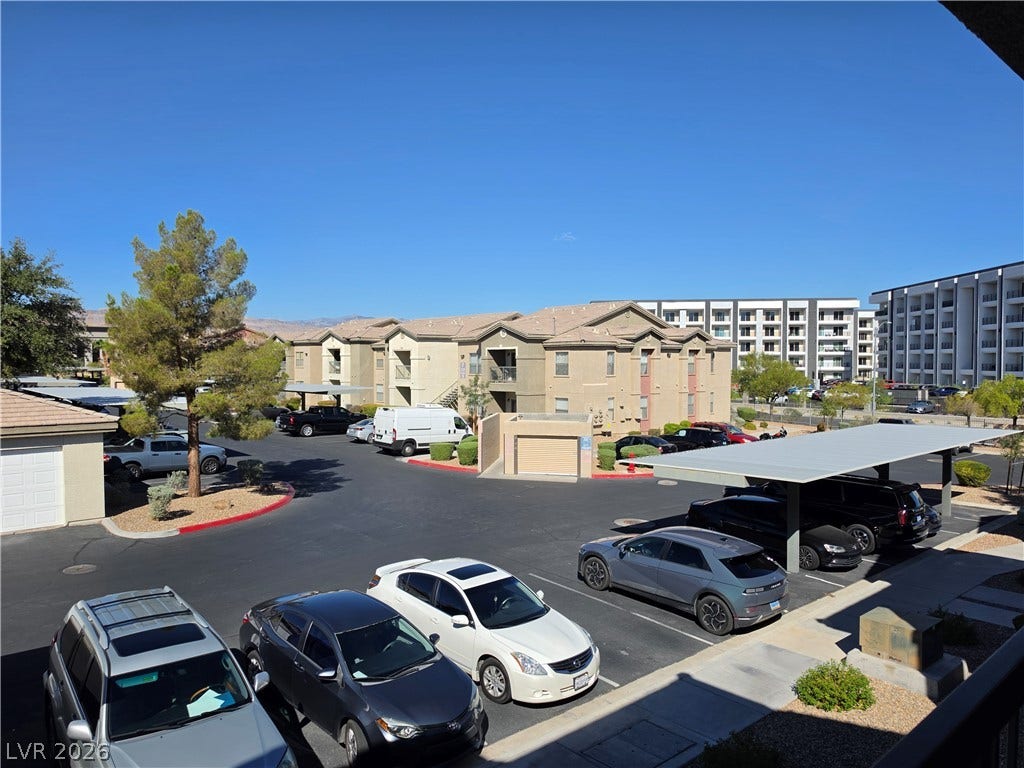 8000 W Badura Avenue, #2111, Las Vegas, NV 89113 An elevated view overlooks the community parking structures and multi-level residential buildings.