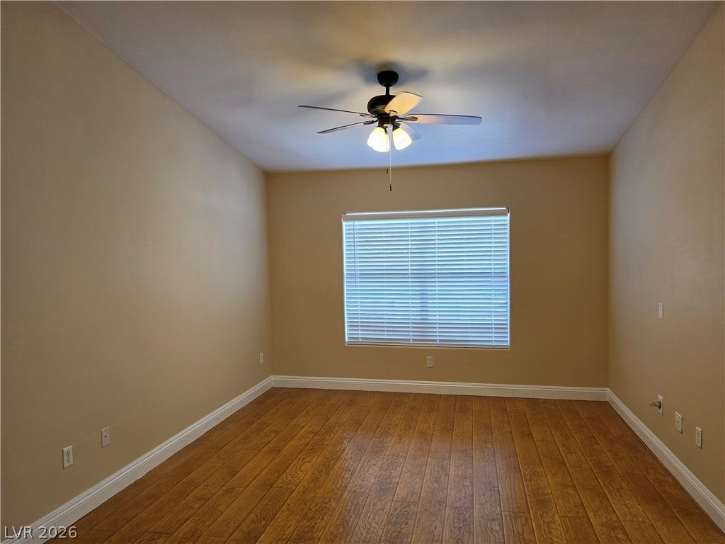 8000 W Badura Avenue, #2111, Las Vegas, NV 89113 Rich wood-look flooring and a wide window with horizontal blinds enhance this versatile room.
