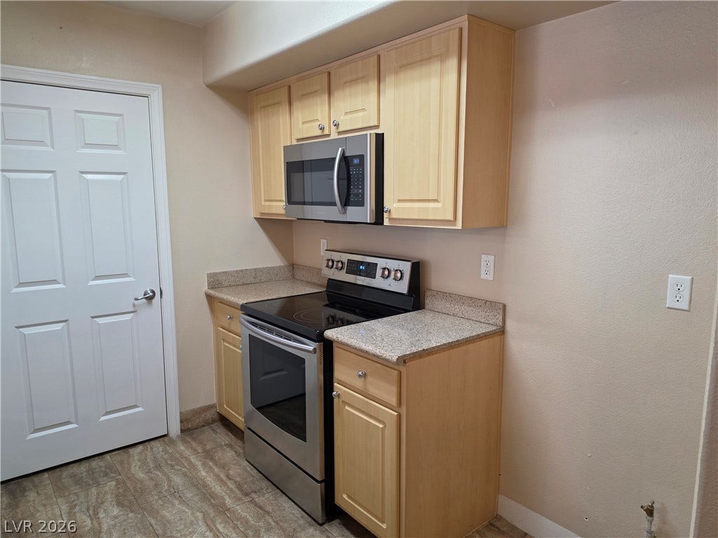 8000 W Badura Avenue, #2111, Las Vegas, NV 89113 Light wood cabinetry pairs with durable granite countertops and matching modern appliances.