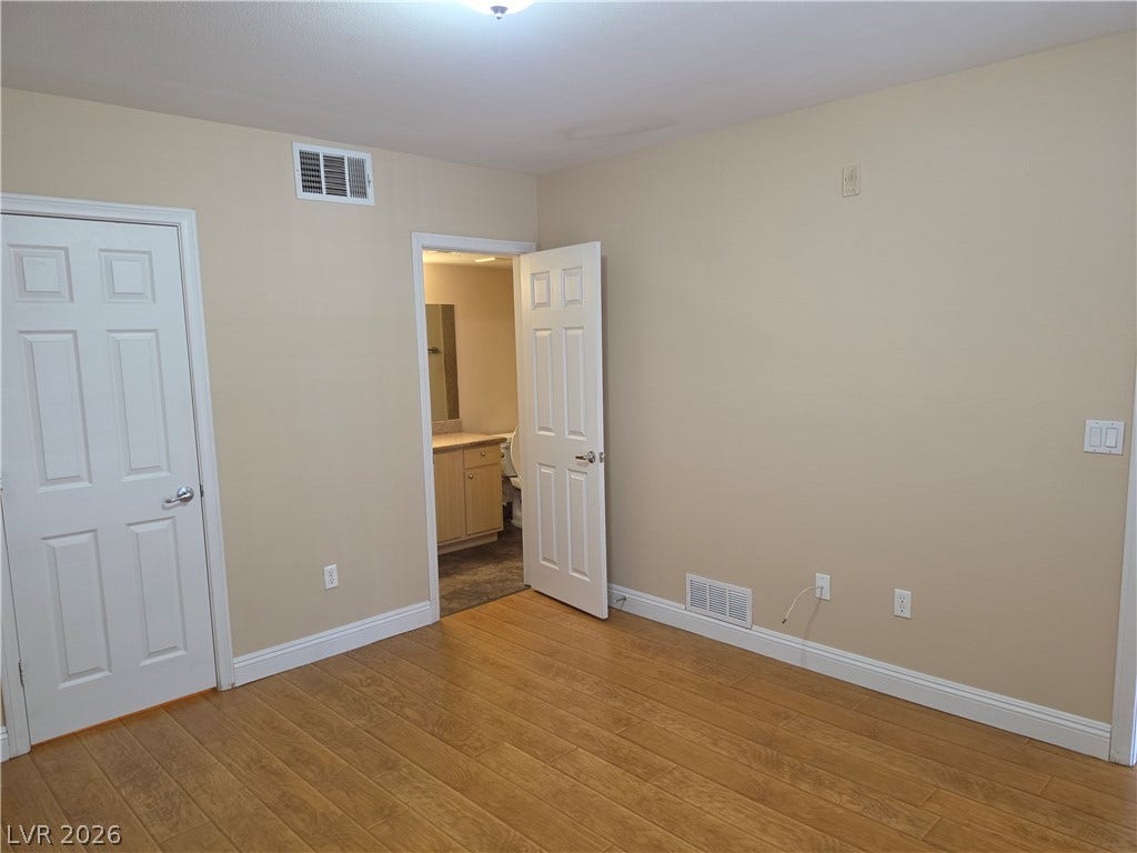 8000 W Badura Avenue, #2111, Las Vegas, NV 89113 Gleaming hardwood floors and classic baseboards anchor this versatile bedroom space featuring an attached bathroom.