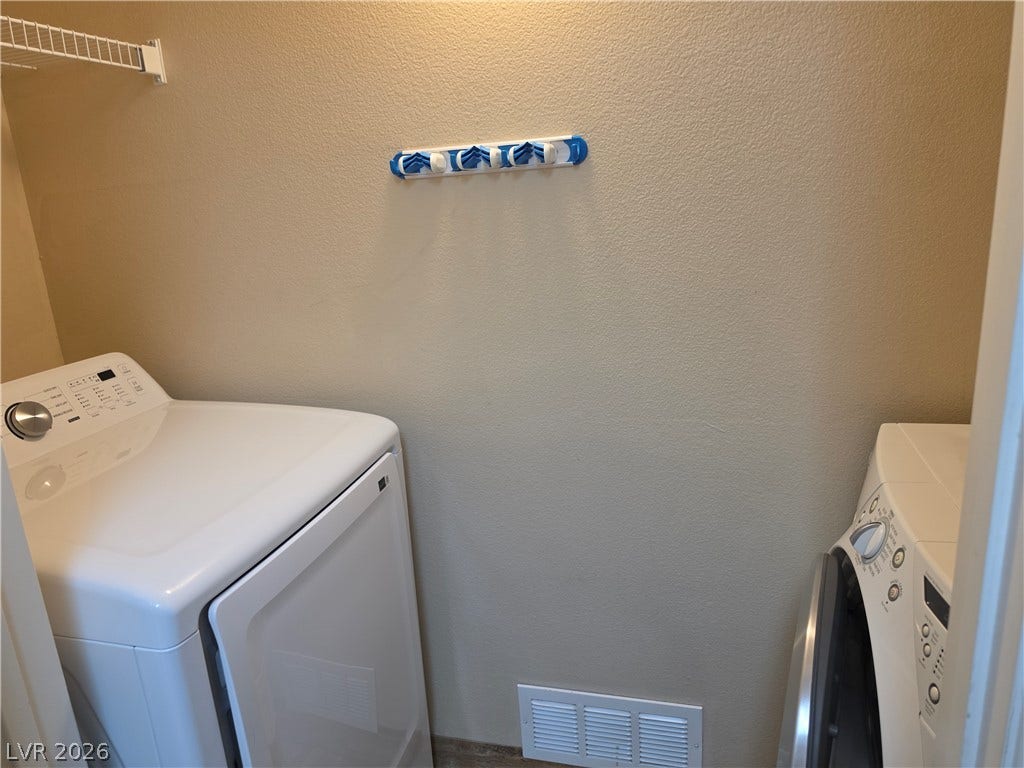 8000 W Badura Avenue, #2111, Las Vegas, NV 89113 Functional utility space features textured walls and integrated laundry appliances.