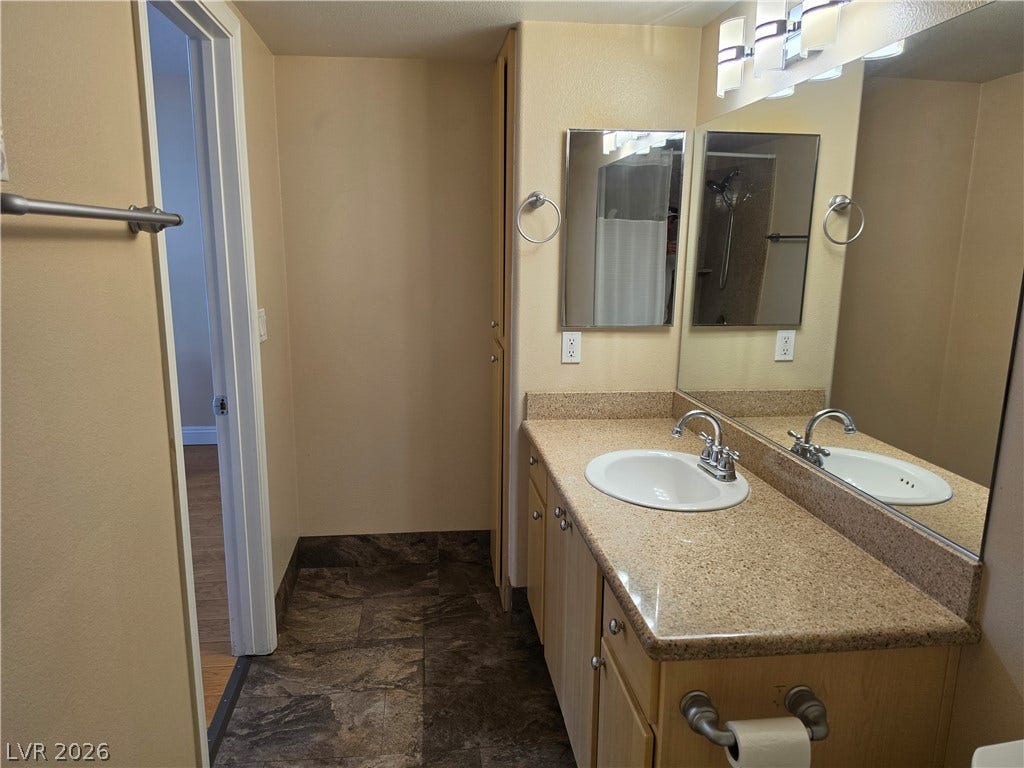 8000 W Badura Avenue, #2111, Las Vegas, NV 89113 Polished stone counters and clean tiling define this functional vanity space.