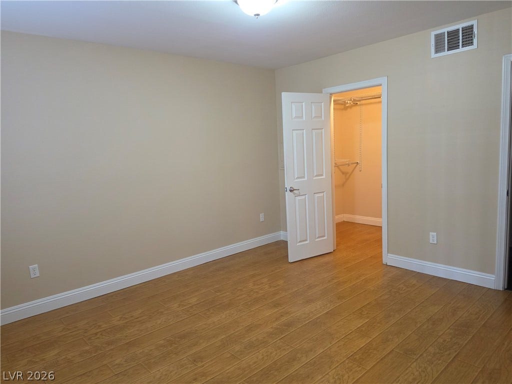 8000 W Badura Avenue, #2111, Las Vegas, NV 89113 Warm wood flooring and clean baseboards anchor this bedroom with a walk-in closet.