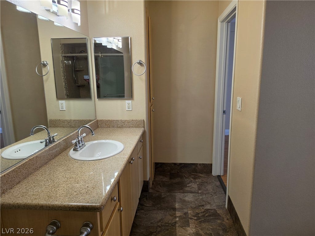 8000 W Badura Avenue, #2111, Las Vegas, NV 89113 Polished stone counters and clean tile flooring define this functional bathroom layout.