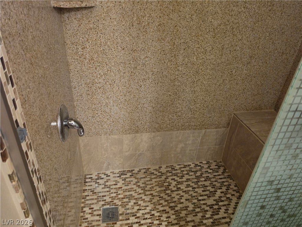 8000 W Badura Avenue, #2111, Las Vegas, NV 89113 Natural stone surfaces and a tiled floor define this modern walk-in shower space.