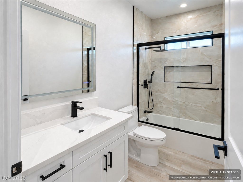 Virtually staged. Polished tile surrounds the modern tub and shower in this elegantly updated bathroom.