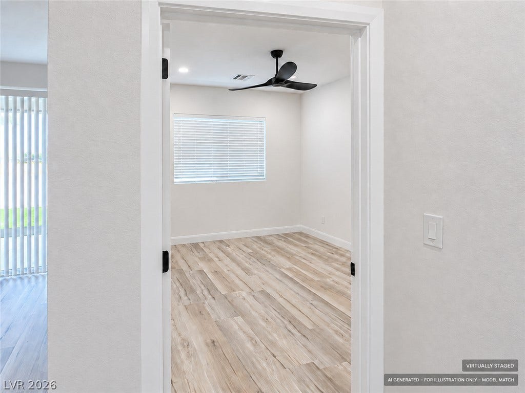 Virtually staged. An inviting doorway reveals light-toned wood flooring and recessed lighting.