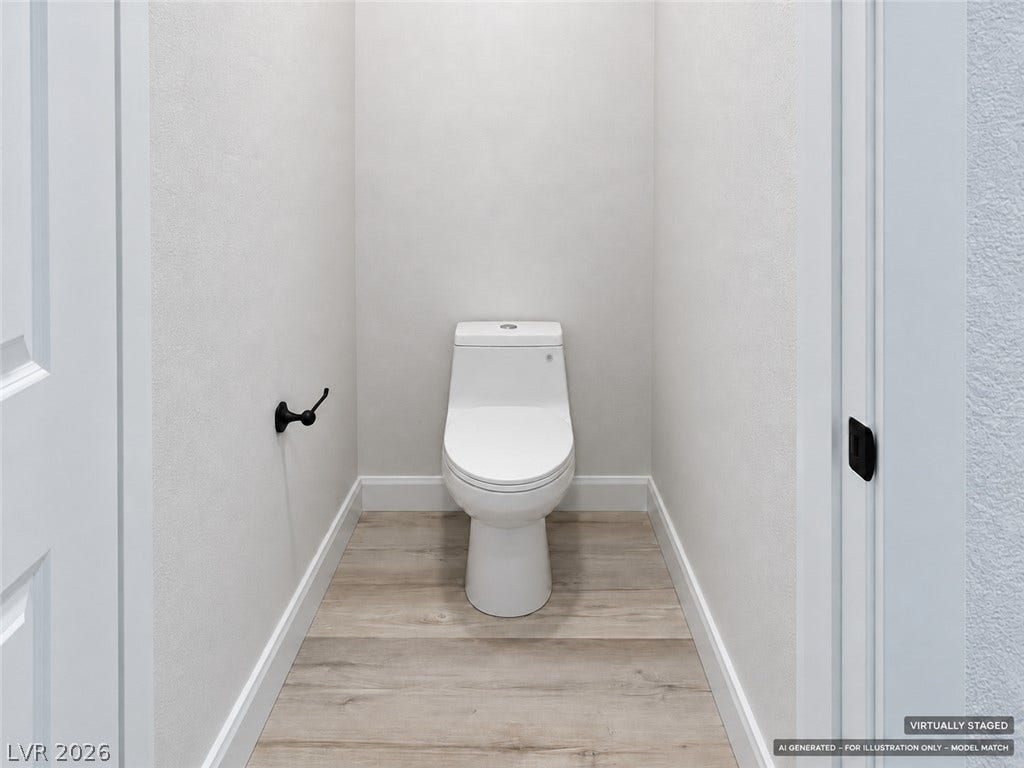 Virtually staged. A private water closet showcases clean minimalist lines and durable wood-look flooring.
