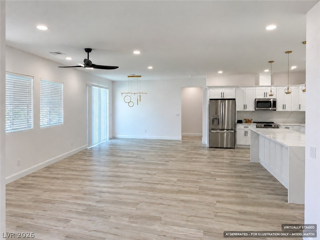Virtually staged. Gleaming wood-look floors unite this expansive open concept kitchen and living area.
