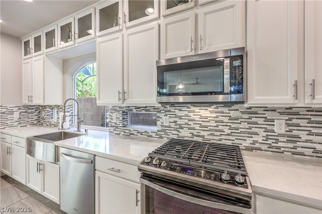 9267 Galen Glen Court, Las Vegas, NV 89139 Modern stone quartz countertops and sleek cabinetry elevate this light-filled cooking space.