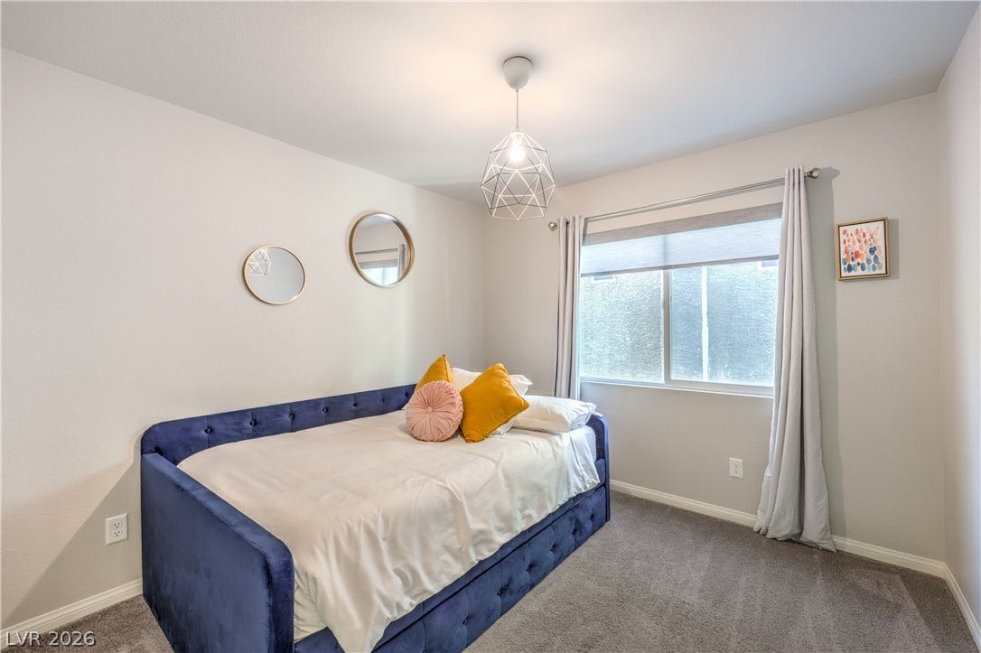 9267 Galen Glen Court, Las Vegas, NV 89139 Bedroom #3 features a wide window that illuminates the soft carpeting, custom closet, and smooth walls of this cozy bedroom.