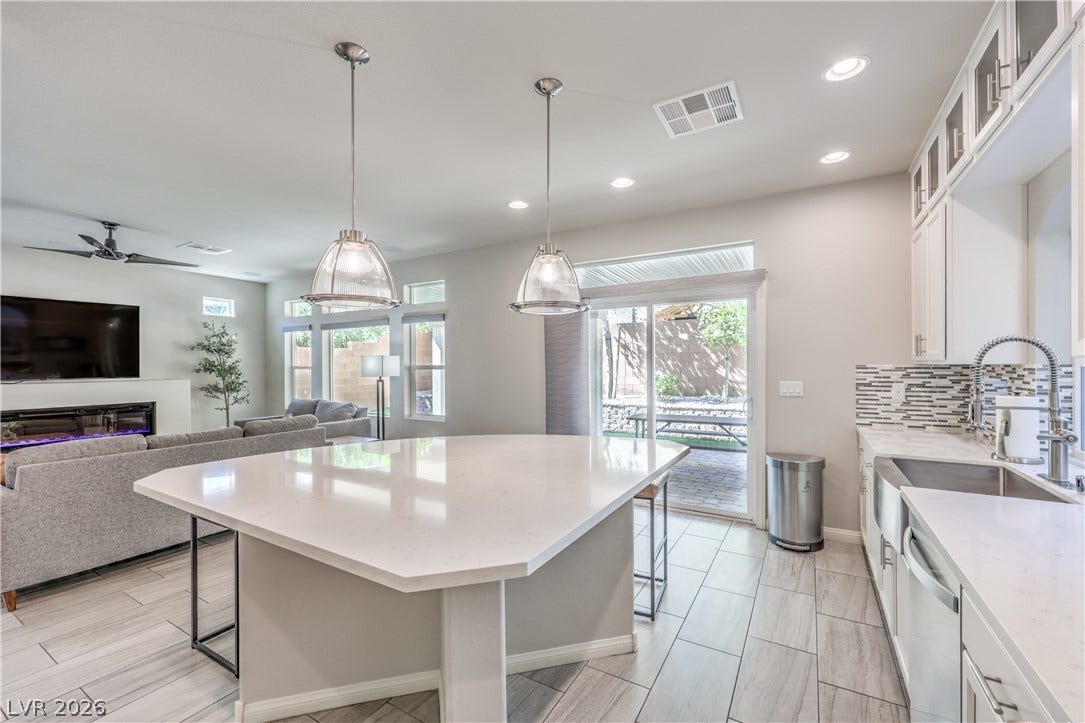 9267 Galen Glen Court, Las Vegas, NV 89139 Clean tile flooring and quartz countertops anchor this modern open-concept culinary space.