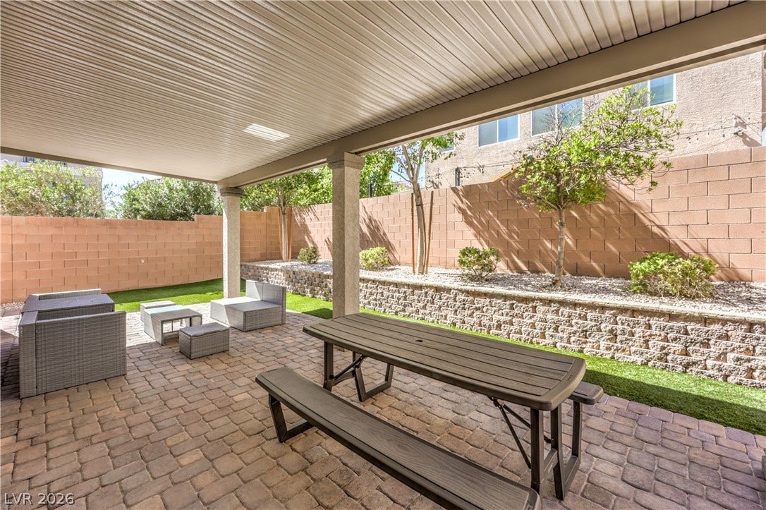 9267 Galen Glen Court, Las Vegas, NV 89139 A spacious covered patio features paver flooring alongside a tiered backyard garden wall.