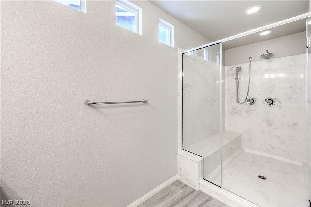 9267 Galen Glen Court, Las Vegas, NV 89139 High clerestory windows bring natural light into a modern walk-in shower with stone surround.