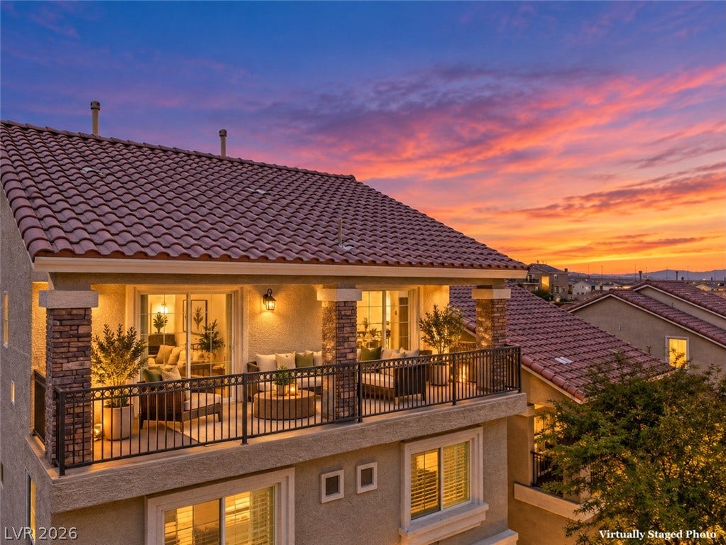 9267 Galen Glen Court, Las Vegas, NV 89139 An elevated tiled balcony showcases stone-wrapped pillars and detailed metal railings beneath a classic tile roof.