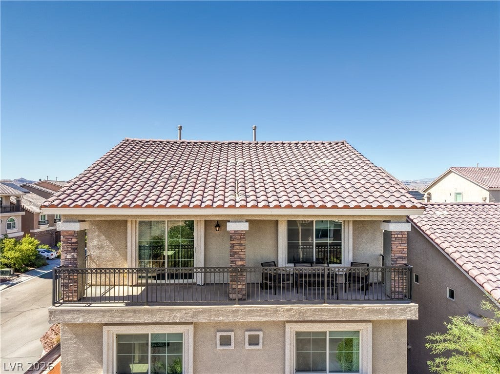 9267 Galen Glen Court, Las Vegas, NV 89139 An upper-level balcony is bordered by ornamental metal railing beneath a Spanish tile roof.