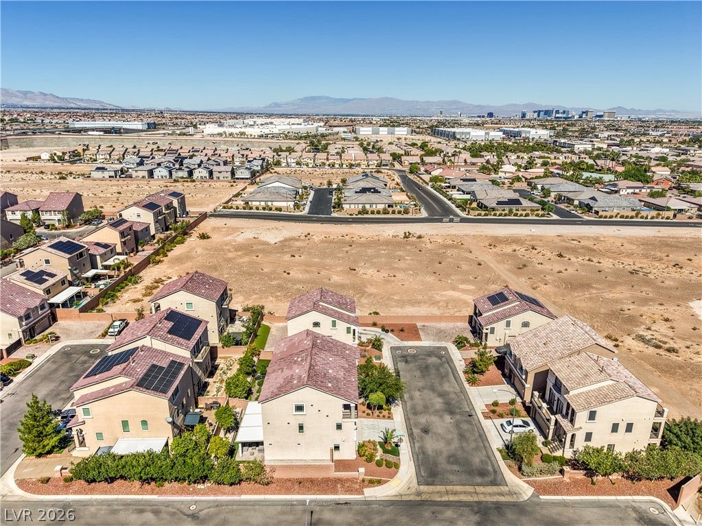 9267 Galen Glen Court, Las Vegas, NV 89139 An aerial perspective showcases a neighborhood of modern homes bordering vast open desert terrain.