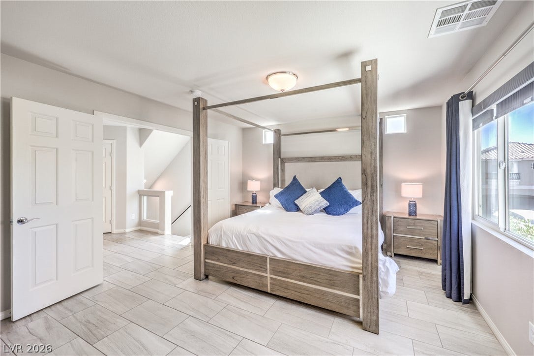 9267 Galen Glen Court, Las Vegas, NV 89139 Tiled flooring and high ceilings define this serene, window-lit bedroom suite.