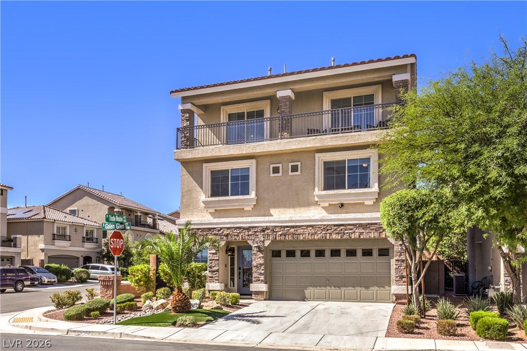 9267 Galen Glen Court, Las Vegas, NV 89139 Multi-level modern architecture showcasing stone accents, an integrated garage, and a spacious upper balcony.