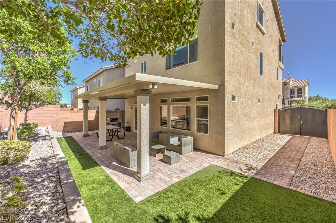 9267 Galen Glen Court, Las Vegas, NV 89139 An inviting covered patio features neat paver flooring alongside low-maintenance synthetic turf.