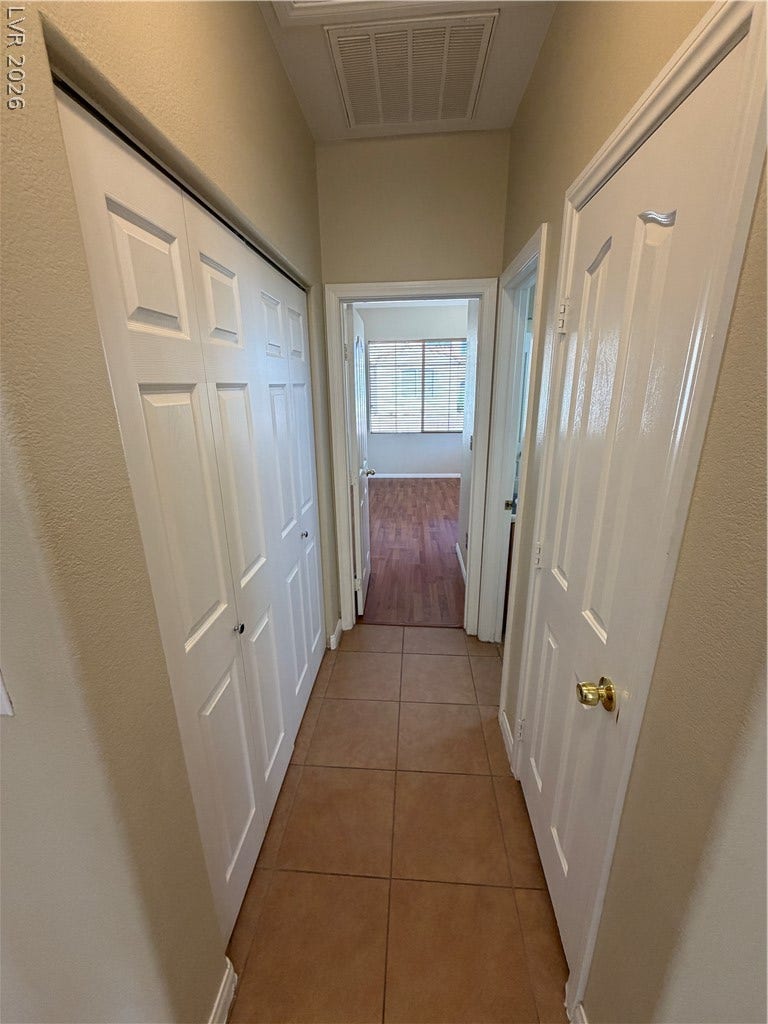 A tiled hallway connects various living spaces through classic paneled doors.