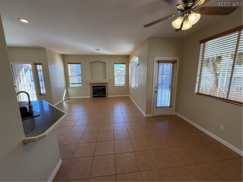 Gleaming tiled ceilings and a central fireplace anchor this inviting living space.