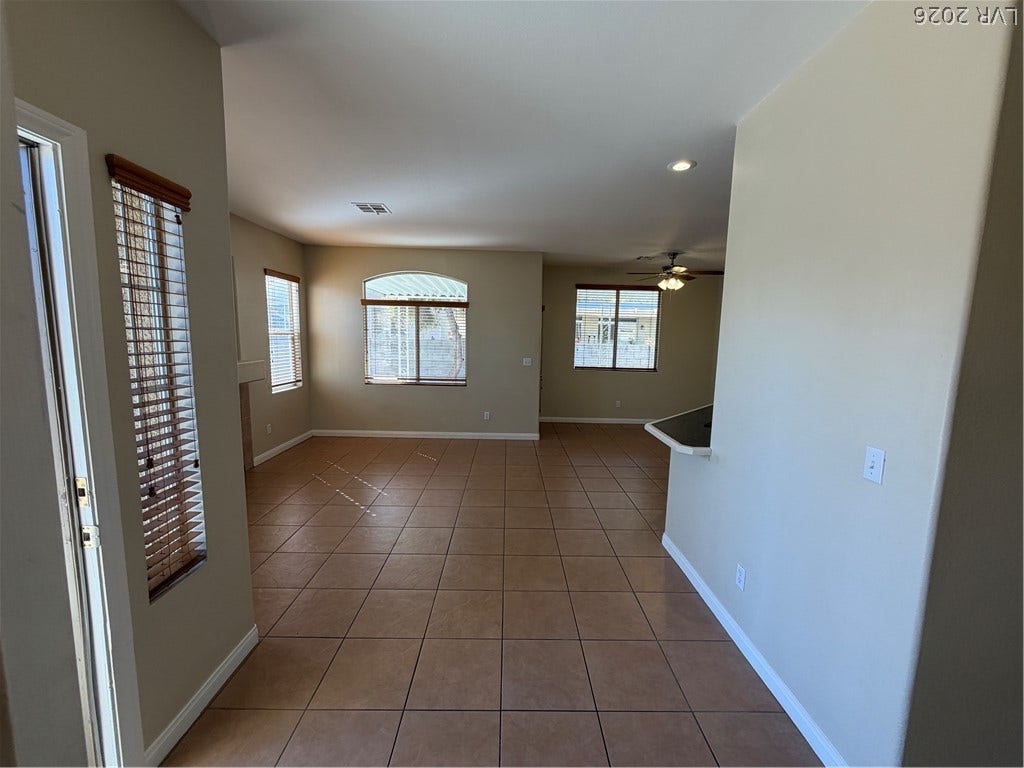 Warm wood-paneled ceilings and tall windows define this open living space.