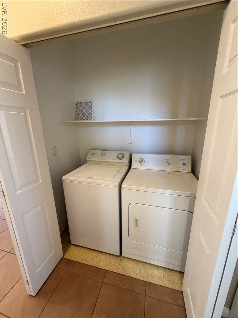 Folding doors open to reveal a dedicated laundry closet equipped with built-in storage shelving.