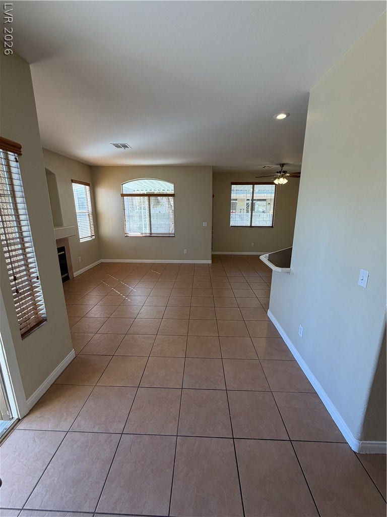 Tile flooring and multiple windows define this open and airy living space.